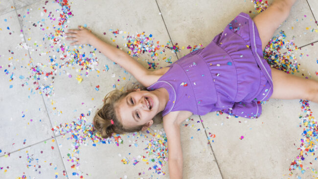 overhead-view-happy-cute-girl-lying-with-confetti-floor Hidegburkolat a nappaliban - kislány és a konfetti "esete" (Fotó: Freepik)
